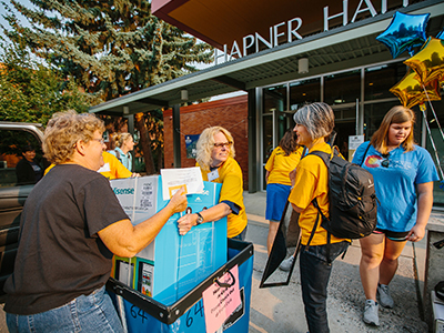 Parents and students unloading a car in front of Hapner Hall.