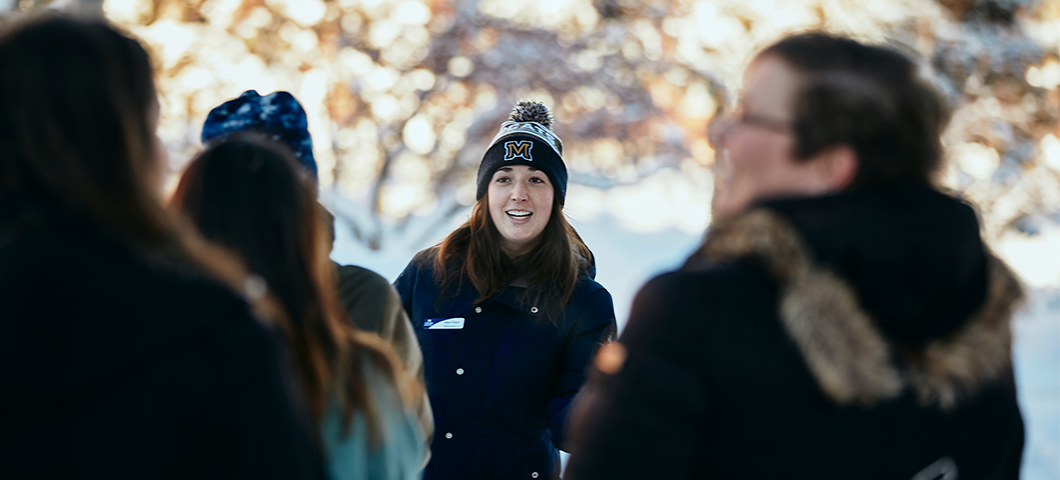 A student leads a tour on a snowy day.