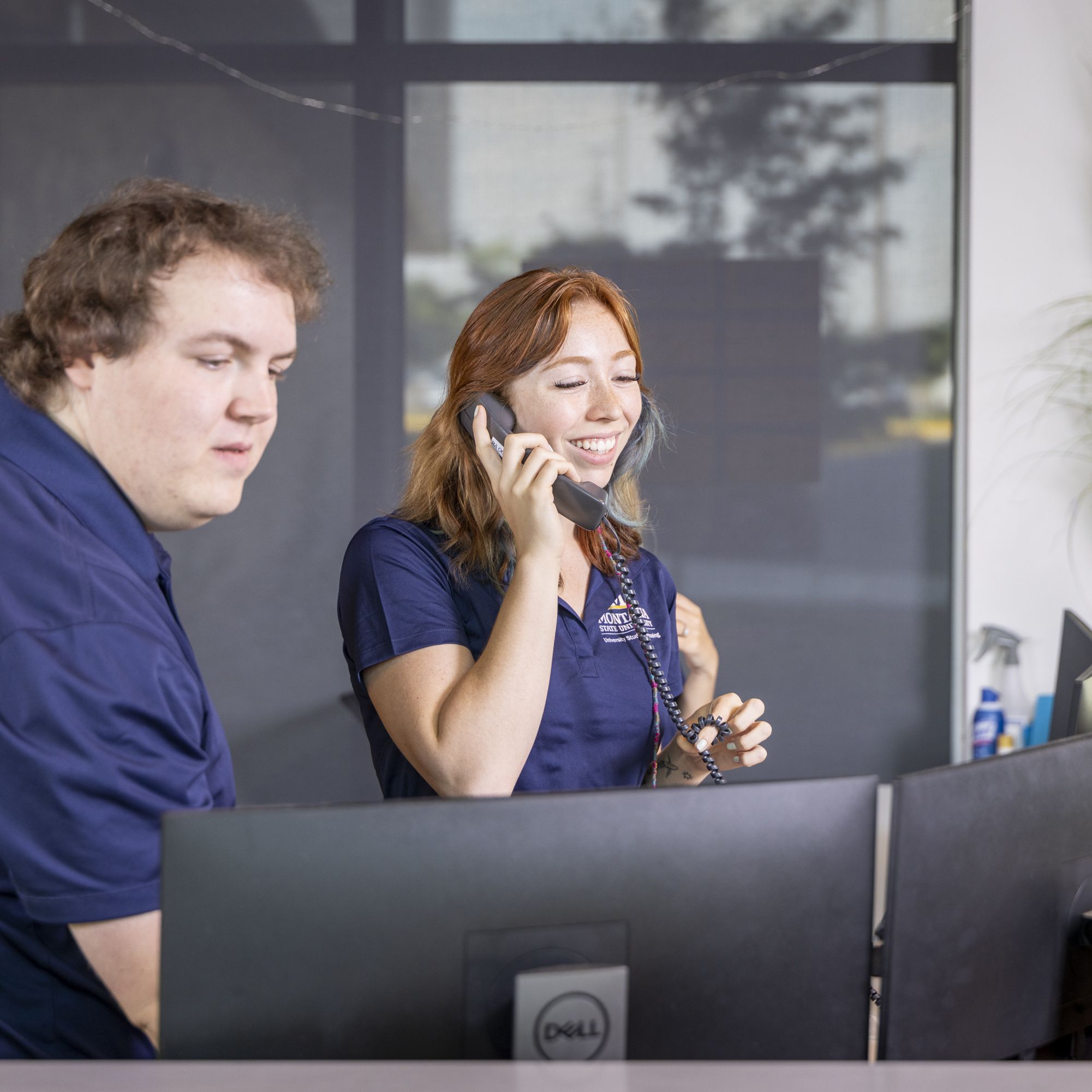 Student Staff on phone at Computer.