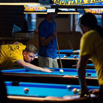 Staff and students playing pool.
