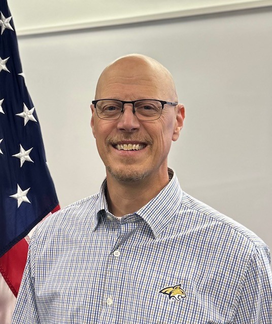 Tom Luhrsen in front of a flag