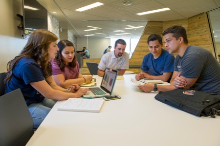 A group of students working together on laptops