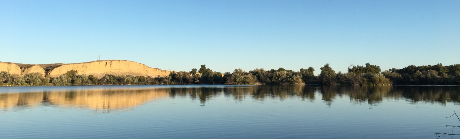 View of cliffs by the Bighorn River as seen across Arapooish Pond