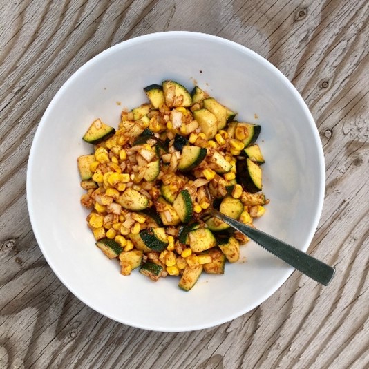 A bowl of corn and zuchinni salad.