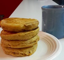 An image of four pumpkin pancakes on a white plate.