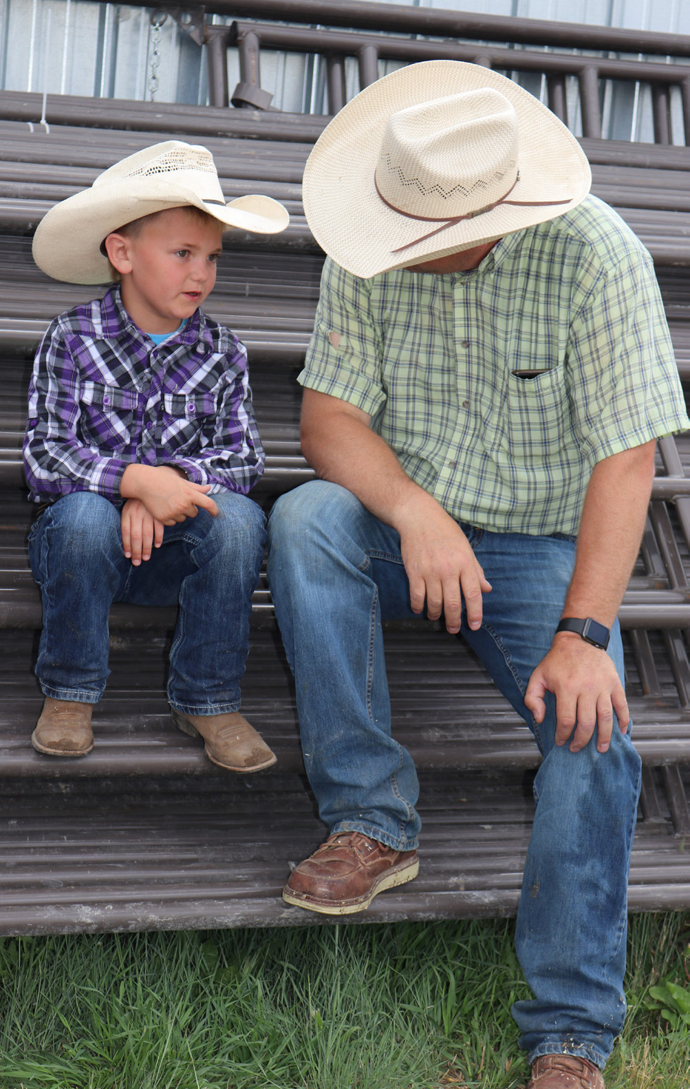 A young boy and a older man sitting on a staircase.