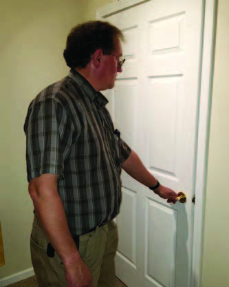 Man closes a white door inside a house.