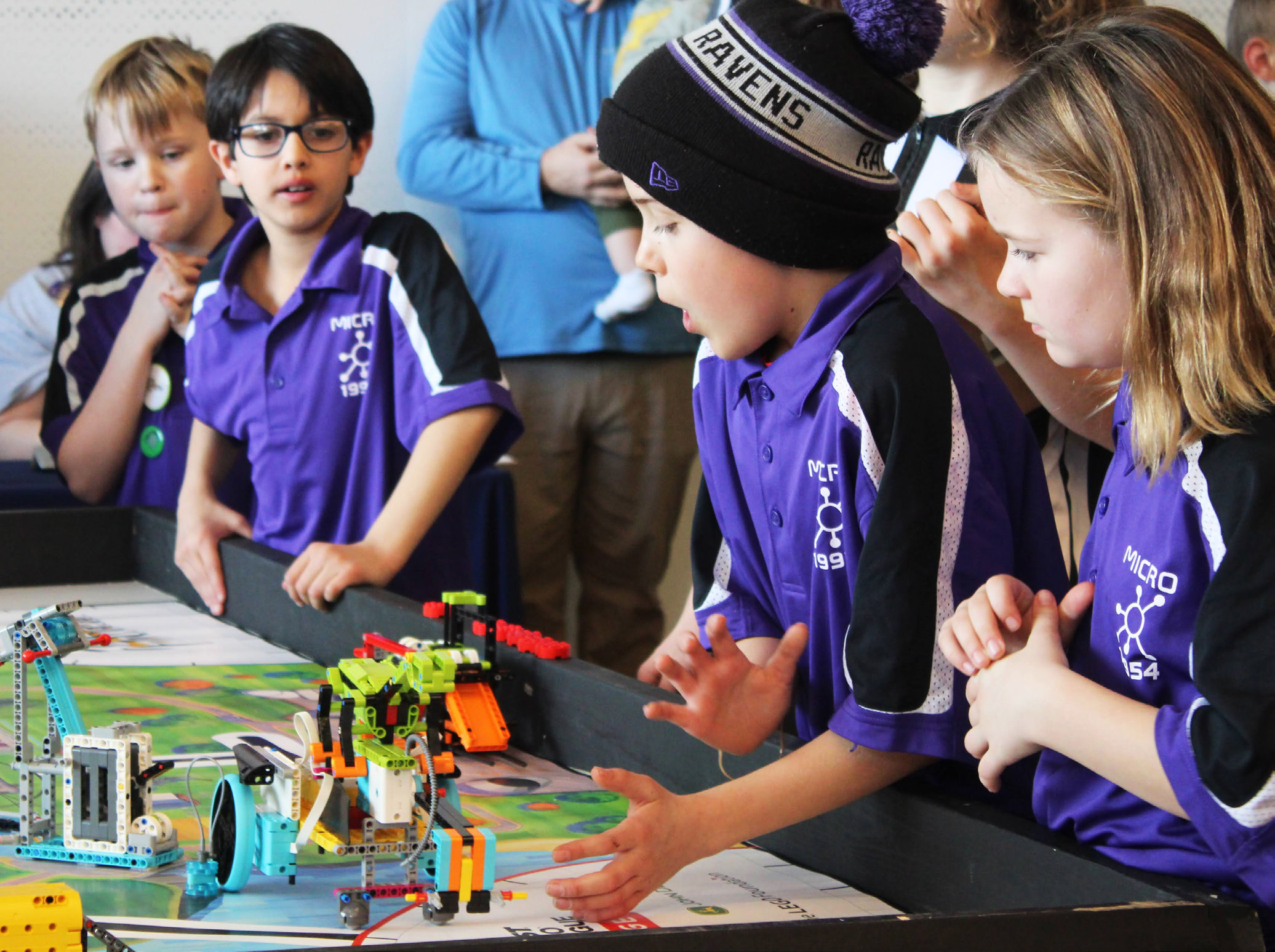 four children showing off their robot excitedly
