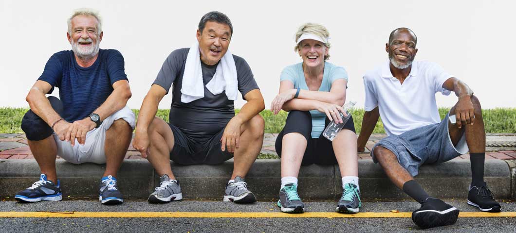 Three men and a woman resting after physical activity.