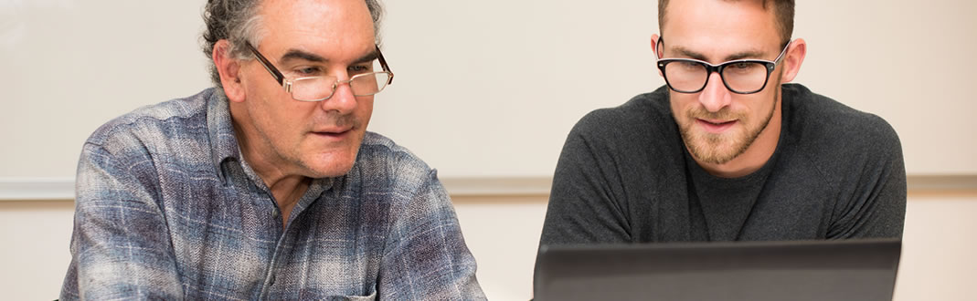 Prof and student working on a computer