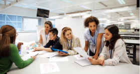 teacher helping students in classroom