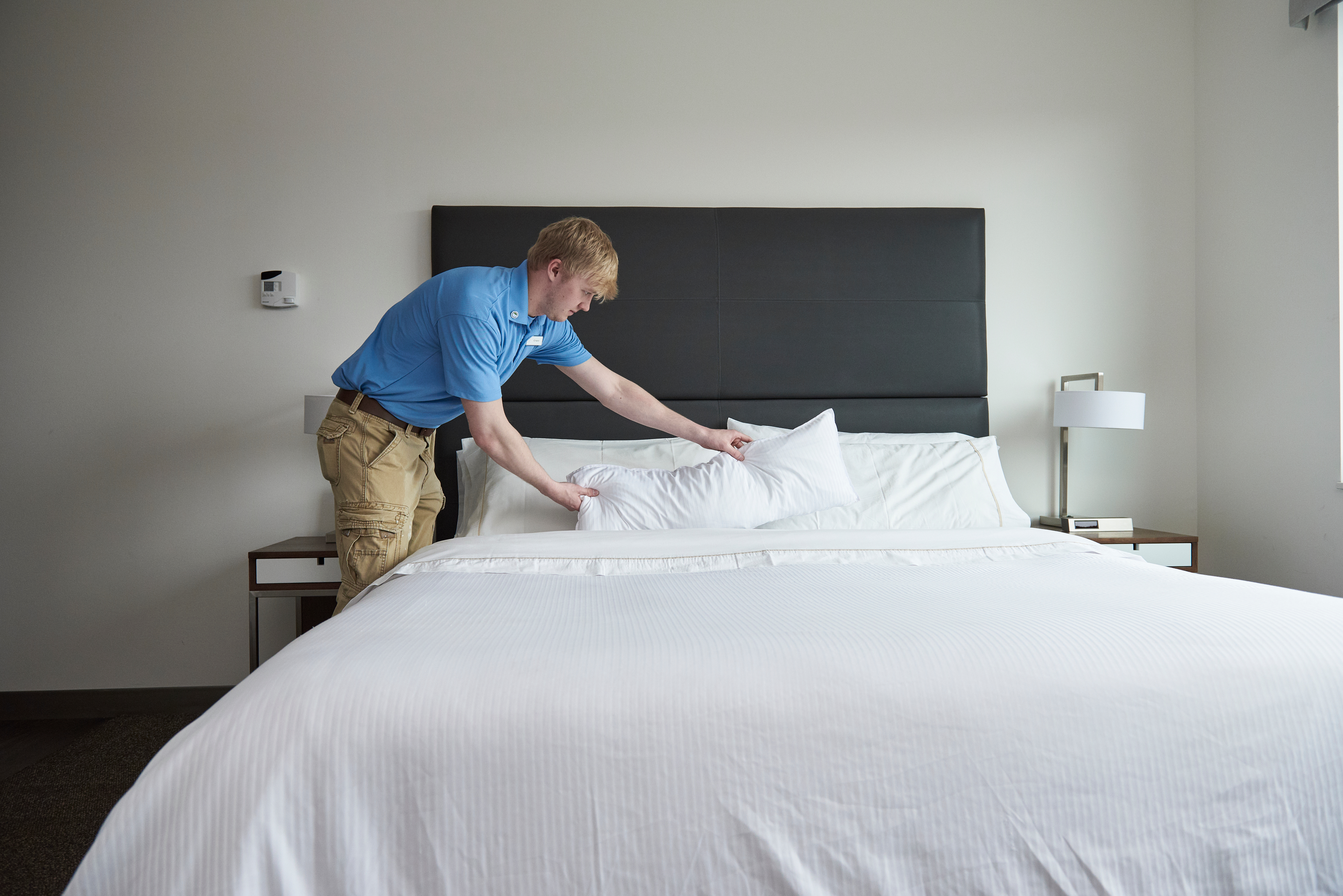 MSU student fixes a hotel bed.