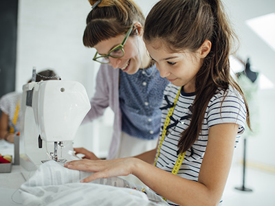 girl learning to sew