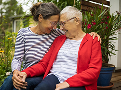 woman and elderly mother holding hands