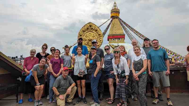 The group smiles for a picture in front of a golden structure.