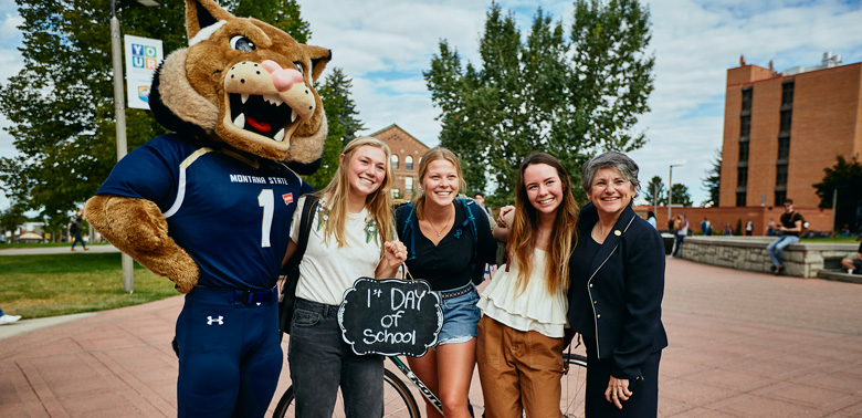 Students posing with President Waded Cruzado and Champ on the first day of classes