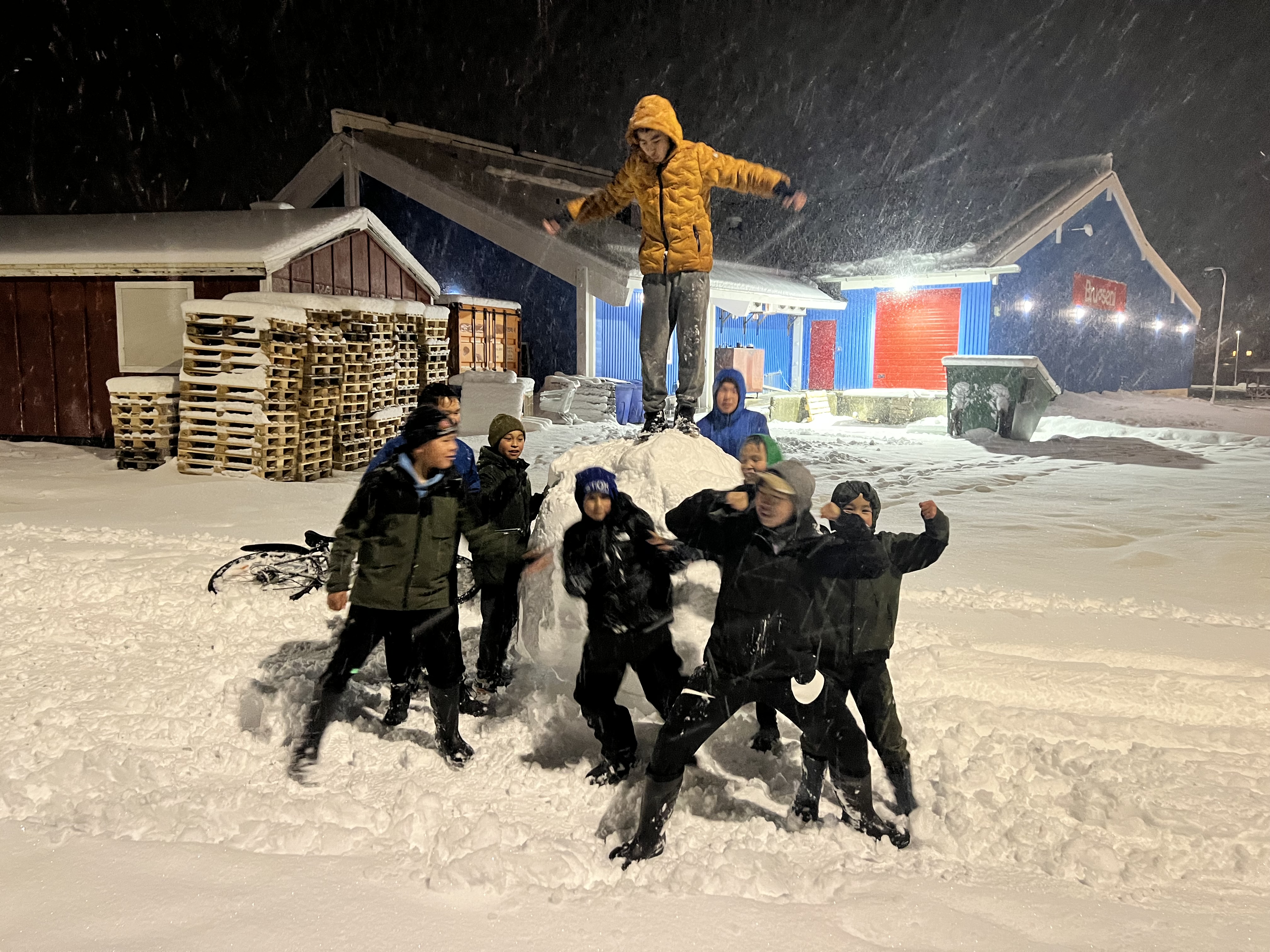 children playing near large snowball