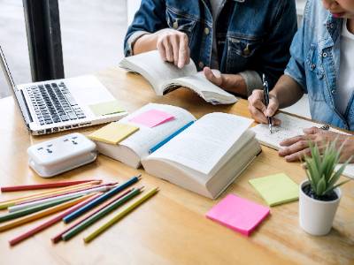 desk with laptop books and people
