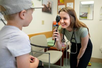 Medical student performing eye exam on pediatric patient