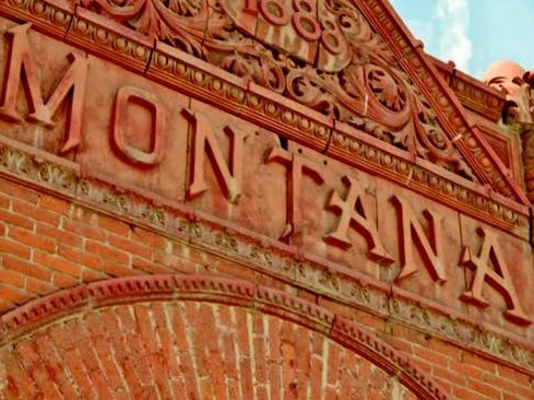 Close up of the front of a brick  building with a facade that reads "Montana."